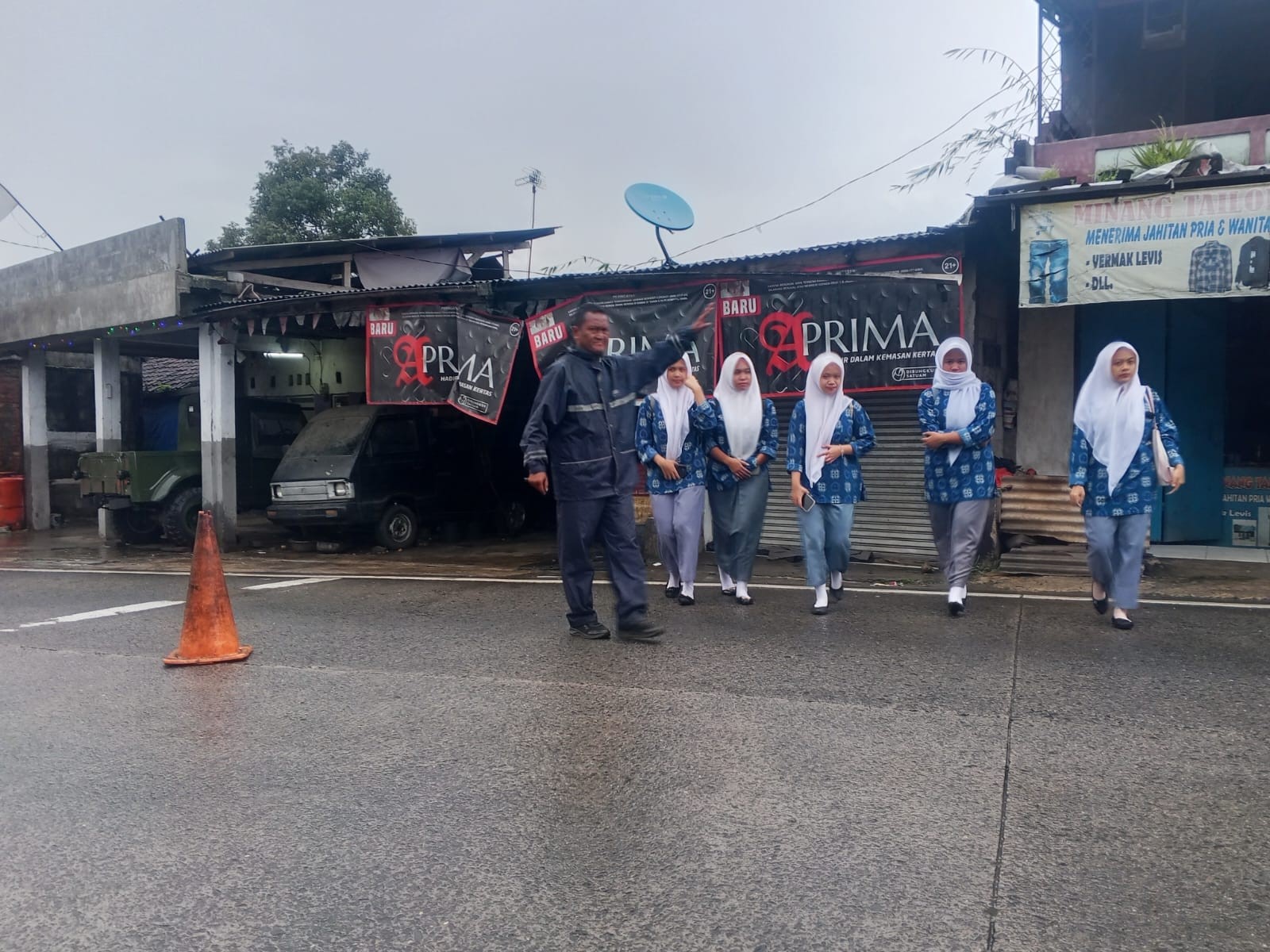 Cuaca Gerimis, Satpam MAN 2 Bogor Tetap Setia Menyebrangkan Siswa dan Warga Madrasah