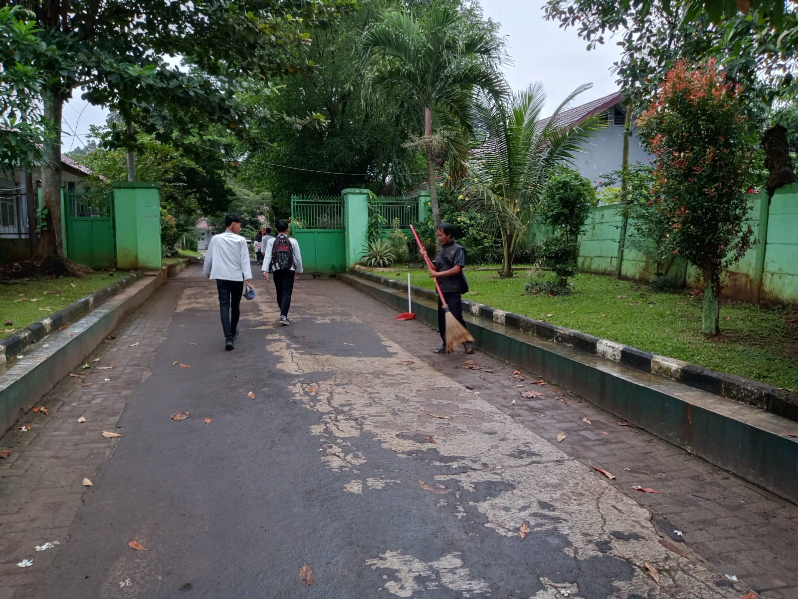 Pegawai Kebersihan Tetap Menjalankan Tugas di Tengah Cuaca Gerimis