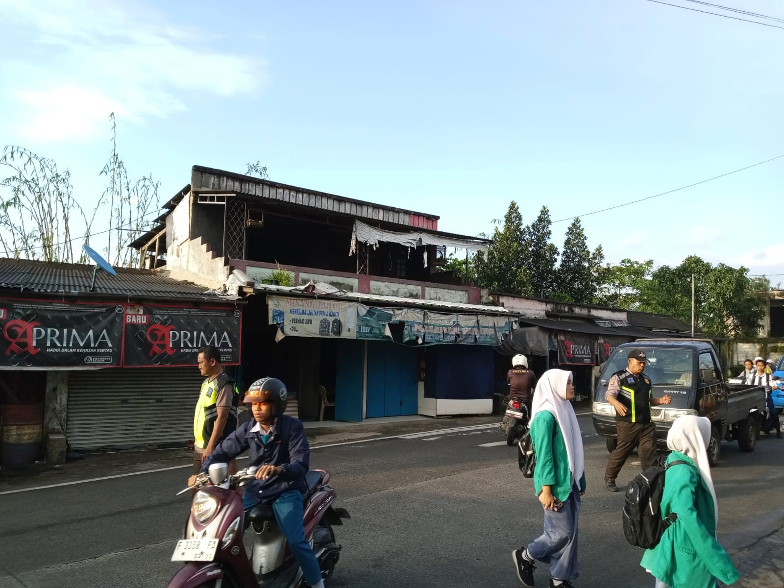 Rutinitas Satpam Menyebrangkan Siswa dan Warga Madrasah