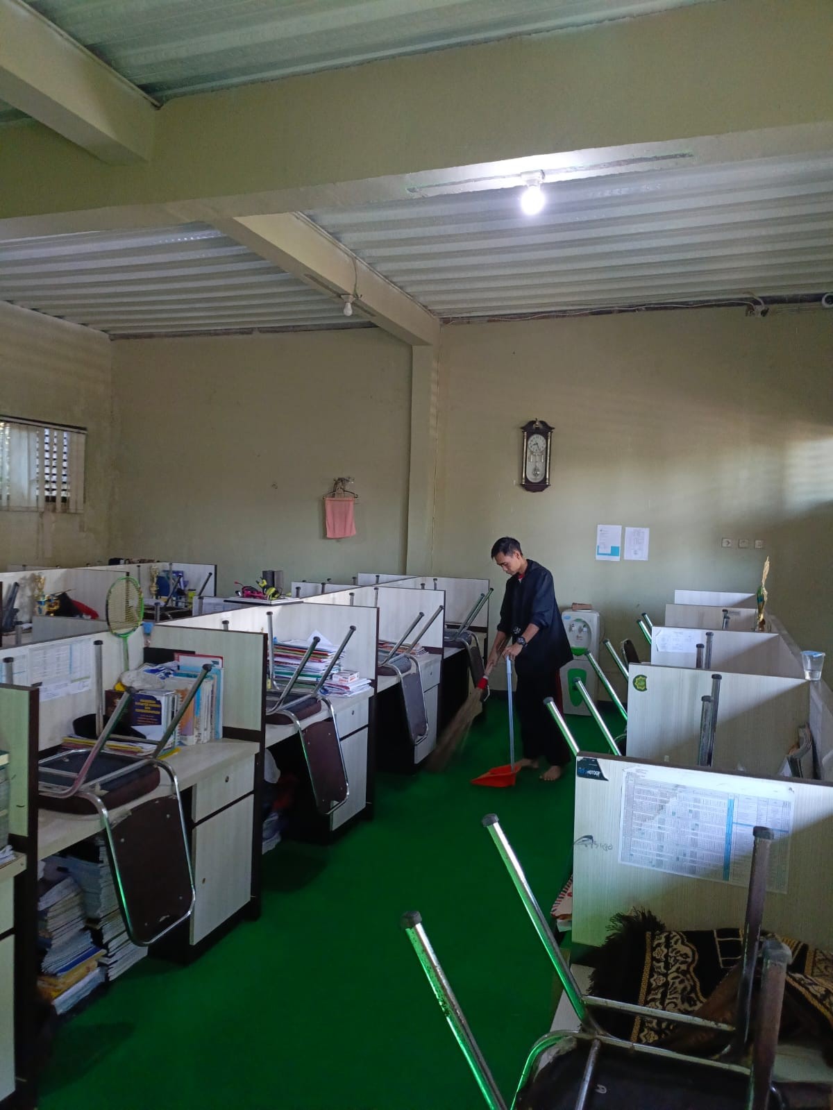 Pegawai Kebersihan Kantor Merapihkan Ruang Guru Saat Libur Sekolah