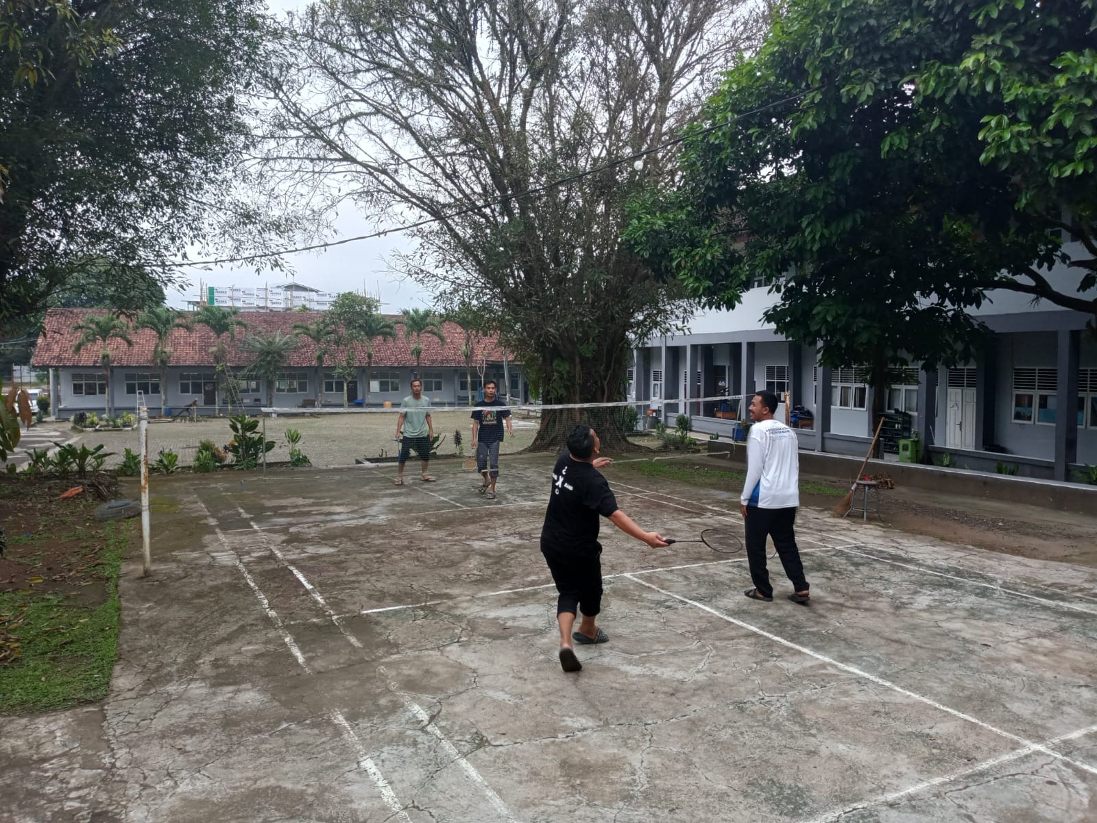 Staf Tata Usaha Meluangkan Waktu Bermain Bulu Tangkis di Tengah Suasana Libur
