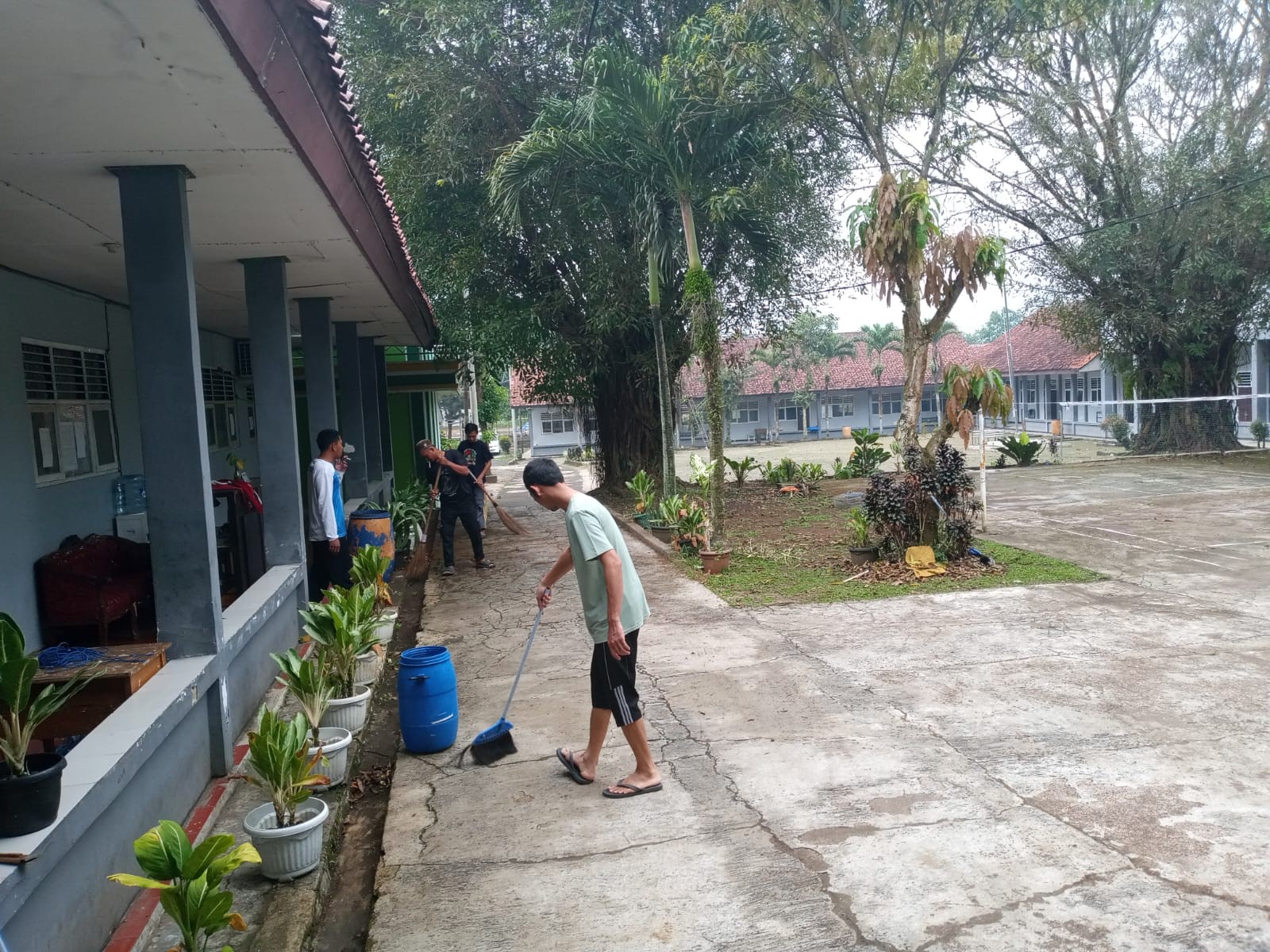 Staf Tata Usaha, Satpam, dan Petugas Kebersihan Bersinergi Membersihkan Halaman Sekolah