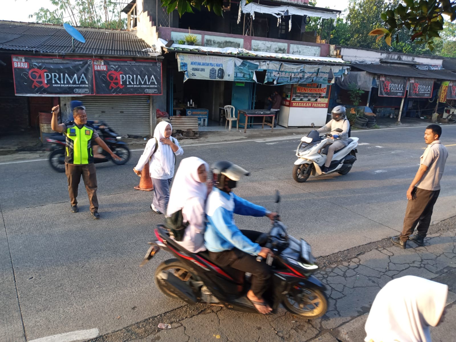 Rutinitas Satpam Menyebrangkan Siswa dan Warga Madrasah