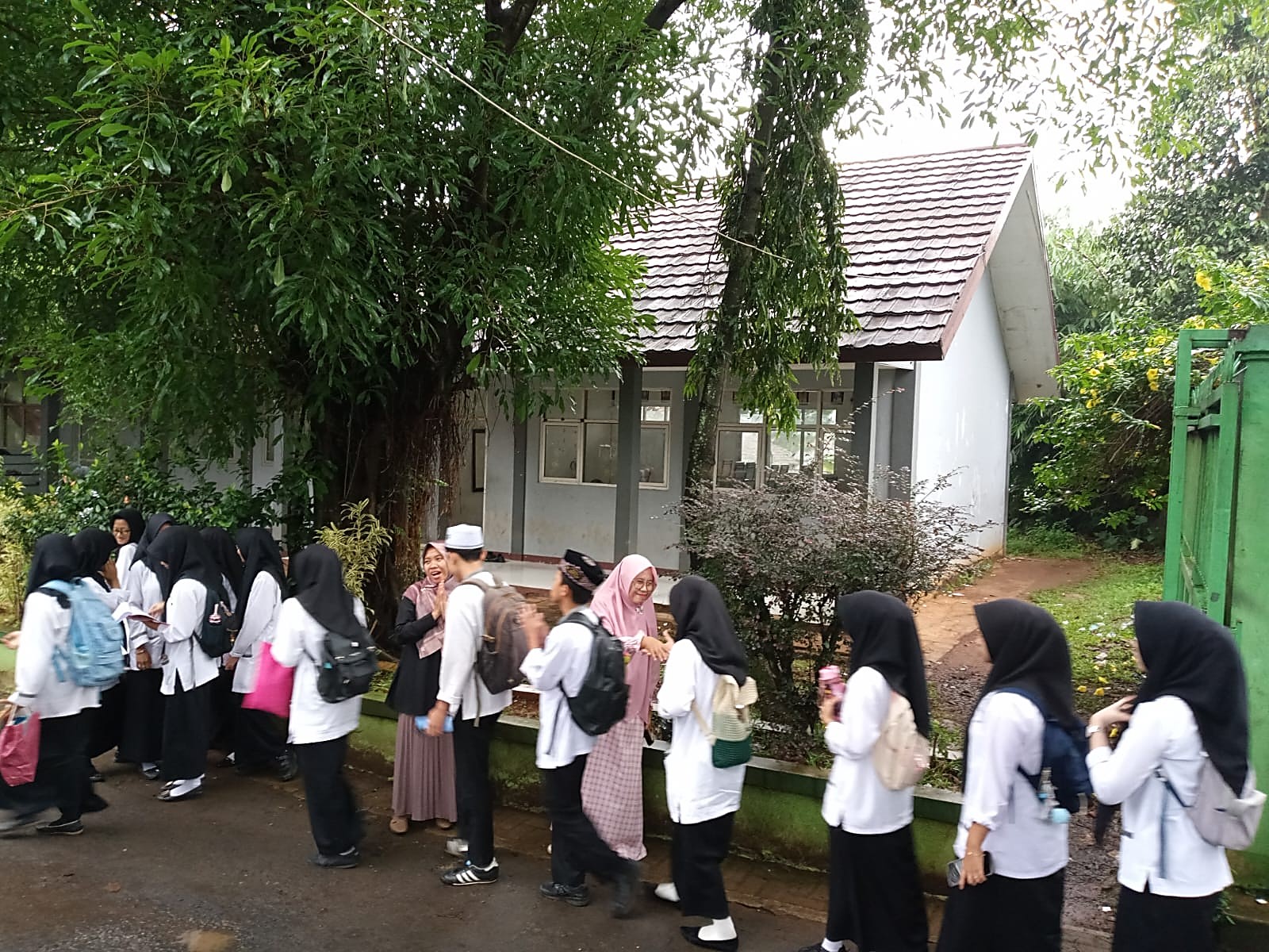 Penyambutan Siswa/i MAN 2 Bogor oleh Guru Piket di Gerbang Sekolah dalam Nuansa Mendung yang Sejuk