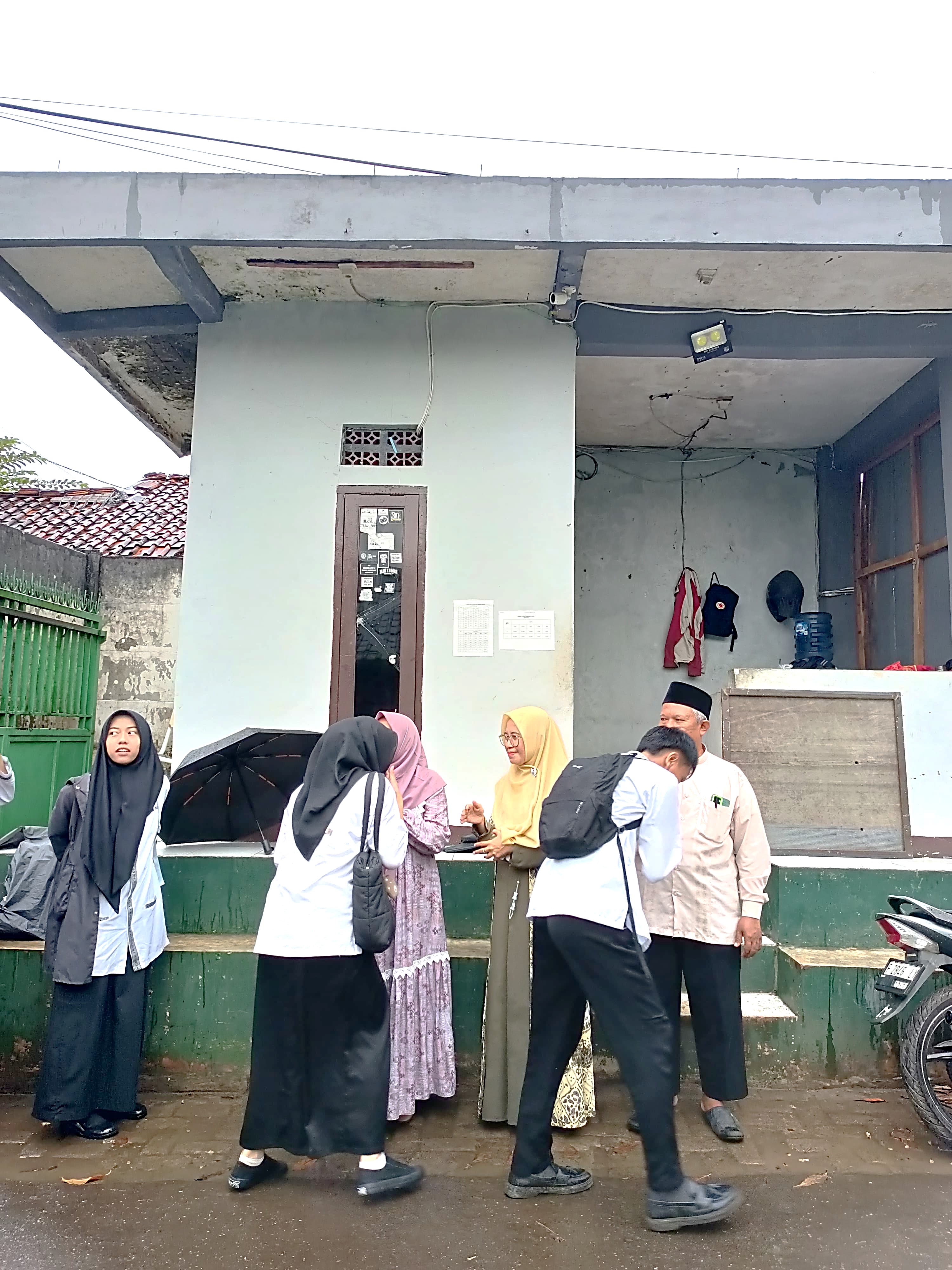 Sambutan Hangat Siswa oleh Guru Piket MAN 2 Bogor di Tengah Gerimis Jumat Berkah